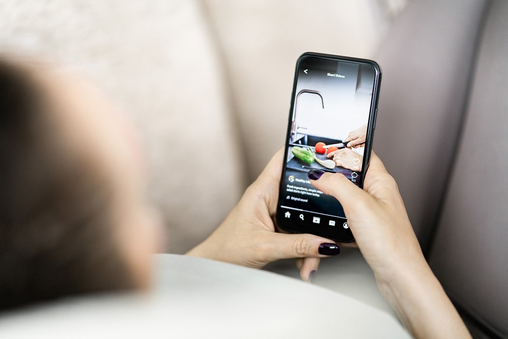 Kvinna som tittar på matreel i sociala medier – reels och karusellinlägg 2025