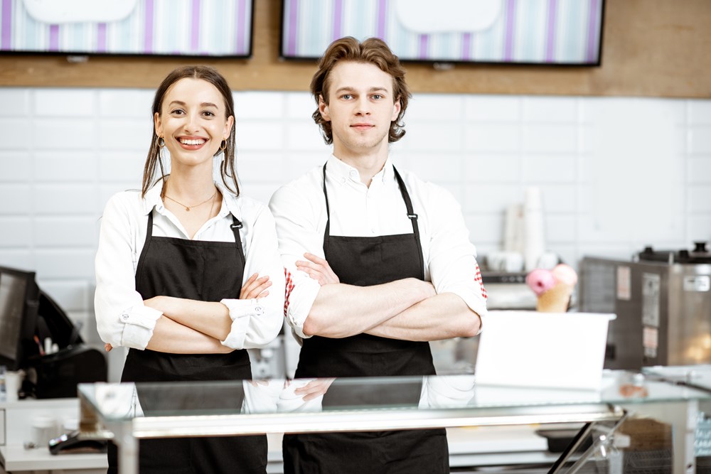 Ungt par som sitter i en restaurang och pratar över en måltid, vilket illustrerar franchisekoncept inom restaurangbranschen.