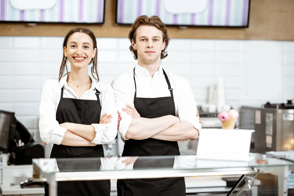 Ungt par som sitter i en restaurang och pratar över en måltid, vilket illustrerar franchisekoncept inom restaurangbranschen.