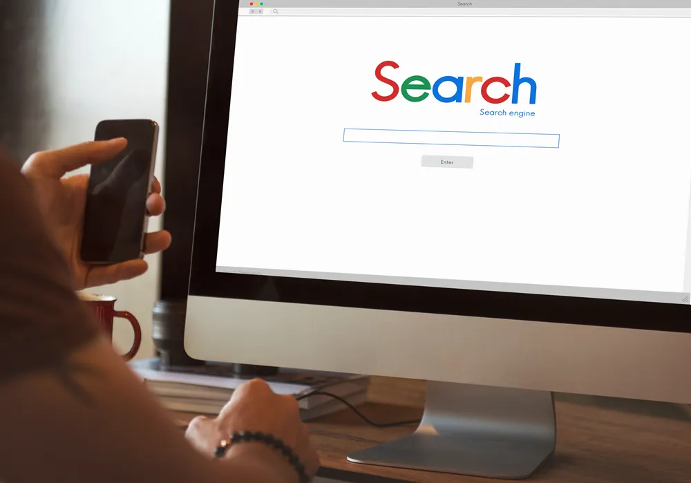 Företagare använder dator och mobil för Google Ads och sökannonsering