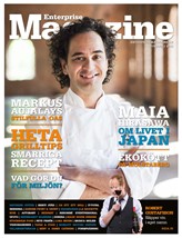 Bilden visar en man med lockigt hår i en vit kockuniform. Längst ner på bilden håller en sommelier upp ett glas vin. Det rör sig om omslaget till tidningen Enterprise Magazine