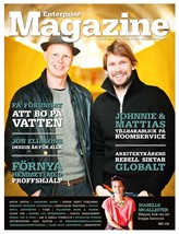 Två män står framför en grön bakgrund och ler in i kameran. Mannen till vänster har en hatt på sig och den andre har blont hår. De lutar sig lätt mot varandra. Det rör sig här om ett omslag till tidningen Enterprise Magazine.