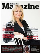 En blond kvinna sitter på en vit stol med armarna över ryggstödet och ler in i kameran. Längst ner ser man en vitthårig man som ler. Det här är omslaget till tidningen Enterprise Magazine.